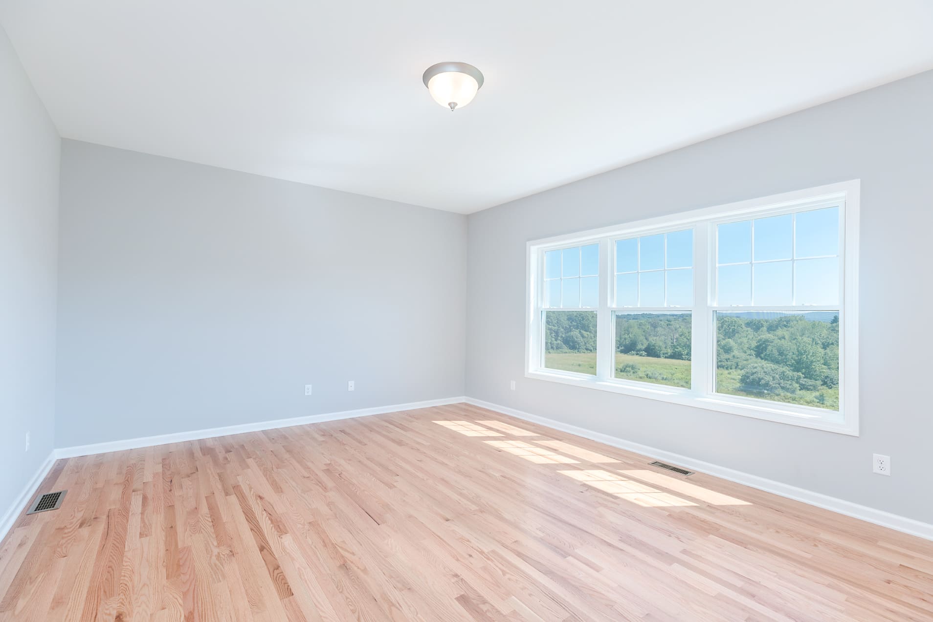 Spacious Living Area with Large Three-Panel Window  | Sunwood Home Builders & Remodelers