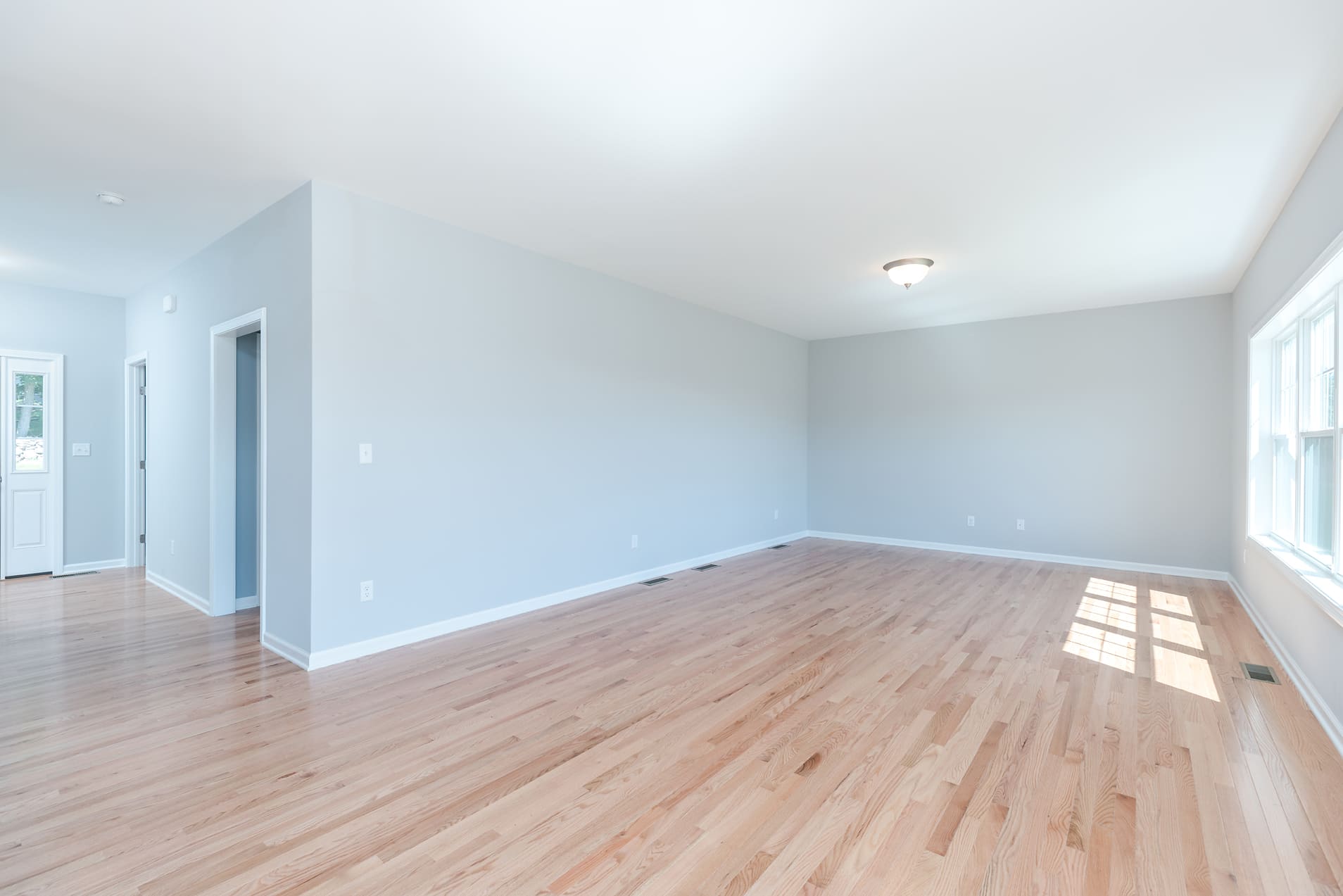 Spacious Living Area with Light-washed Hard Wood Flooring  | Sunwood Home Builders & Remodelers